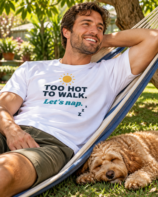 Smiling man relaxing in a backyard hammock wearing the white Too Hot to Walk tee, with his Cavoodle napping beside him (AI-generated image)